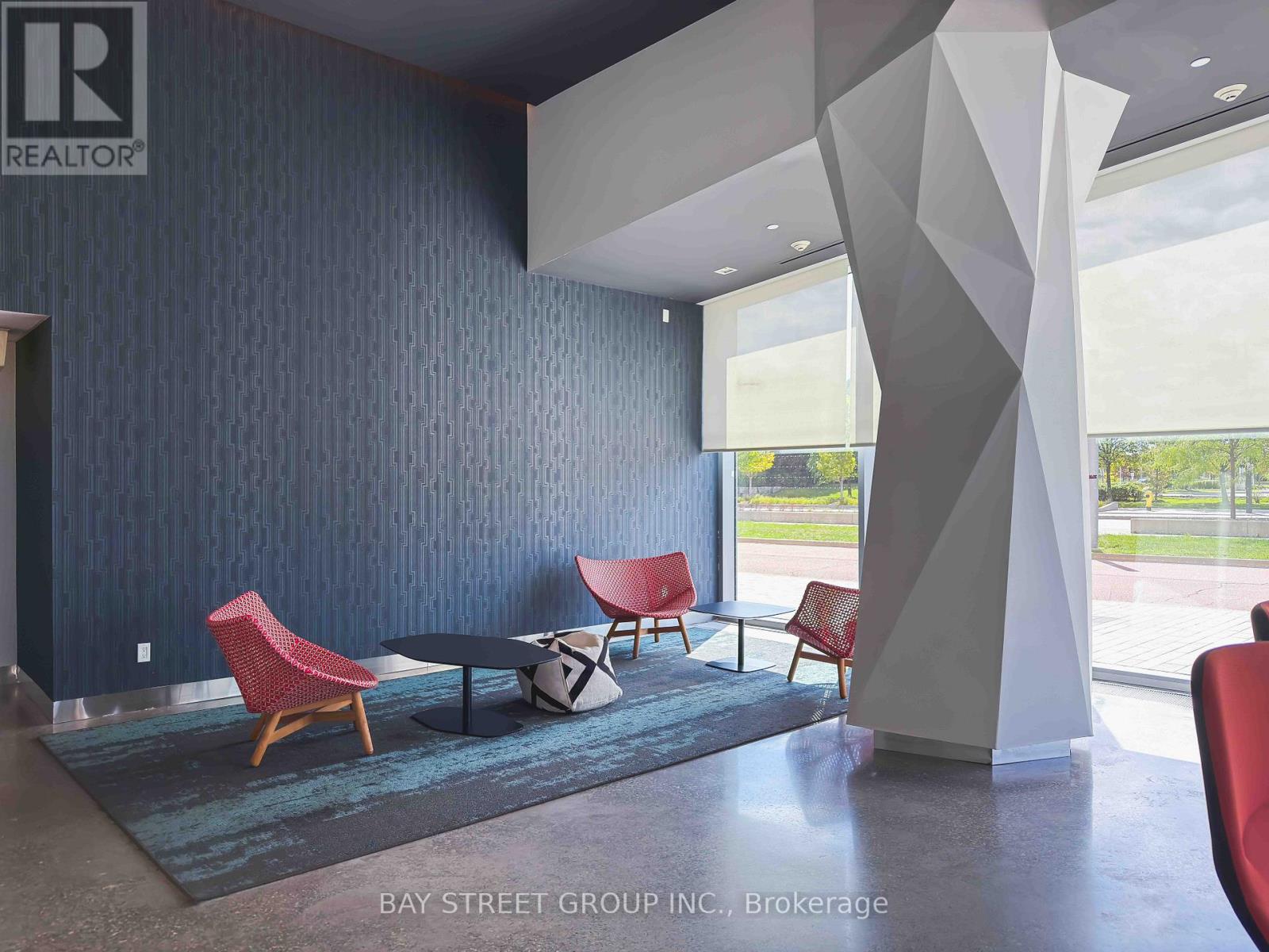 A modern living room with a grey floor and a blue wall.