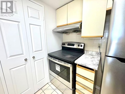 A kitchen with a stove top oven and a refrigerator.