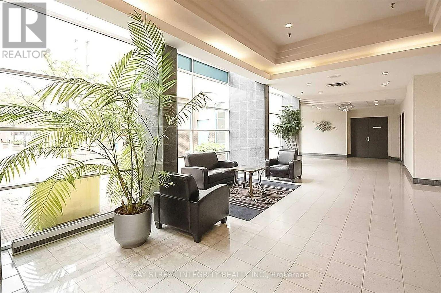 A living room with a large window and a potted plant.