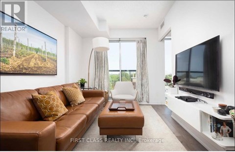 A living room with a brown leather couch and a television on the wall.