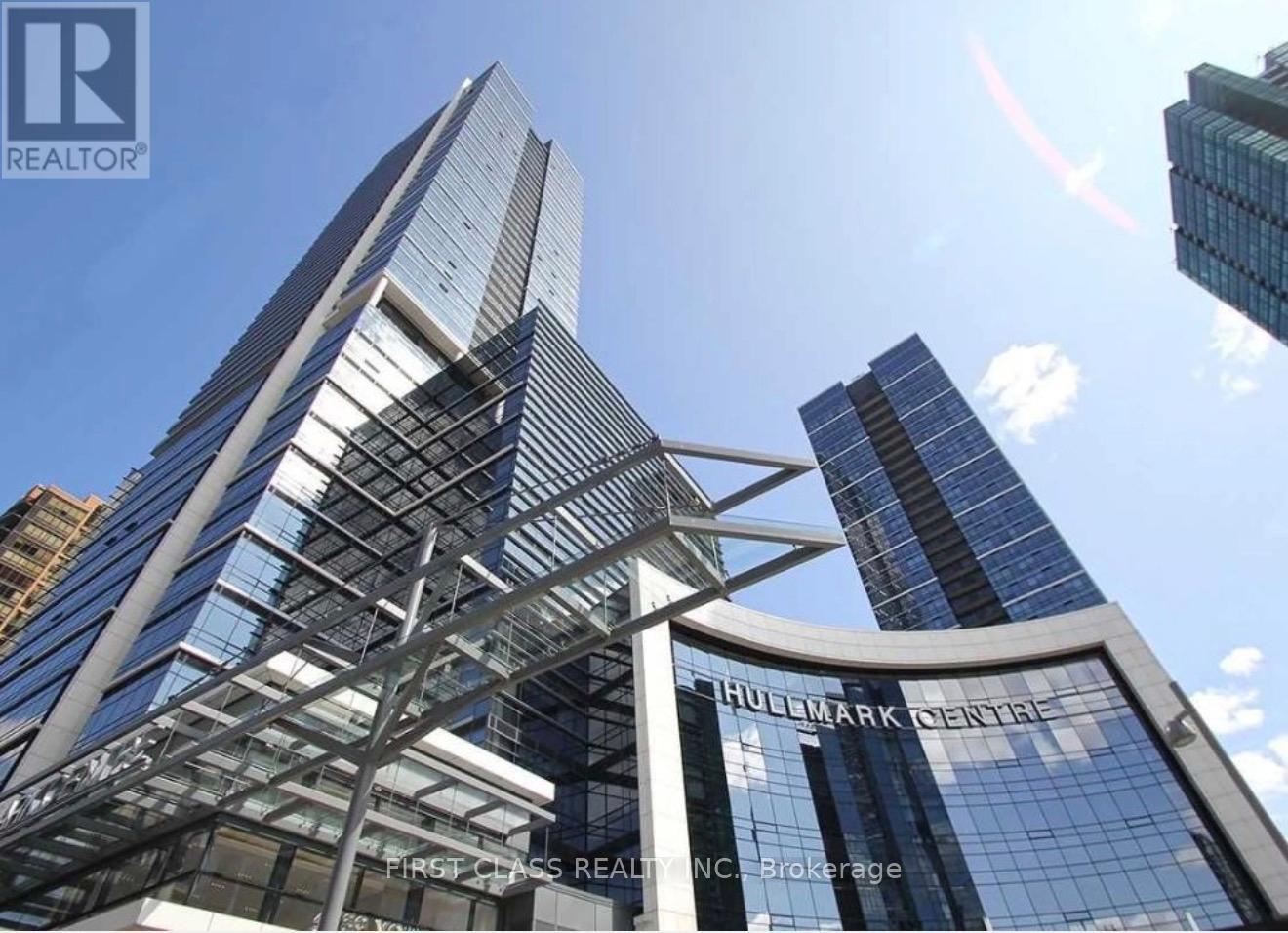A tall building with a glass facade and a sign that reads "Huddlestone Centre".