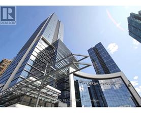 A tall building with a glass facade and a sign that reads "Huddlestone Centre".