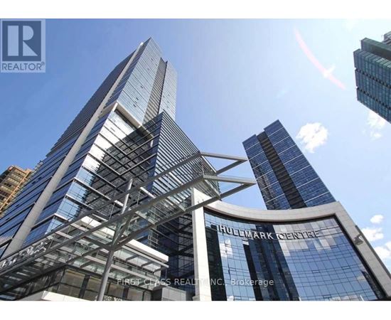 A tall building with a glass facade and a sign that reads "Huddlestone Centre".