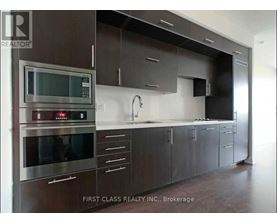 A modern kitchen with dark brown cabinets and stainless steel appliances.