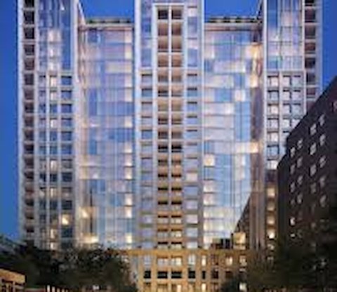 A tall building with many windows is lit up at night.
