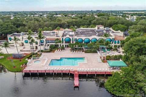 A large building with a pool and a dock in front of it.