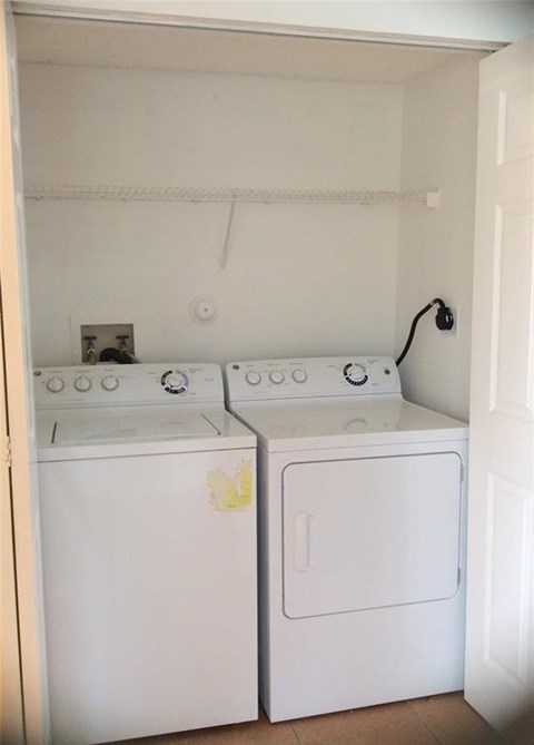 A small laundry room with a washer and dryer.