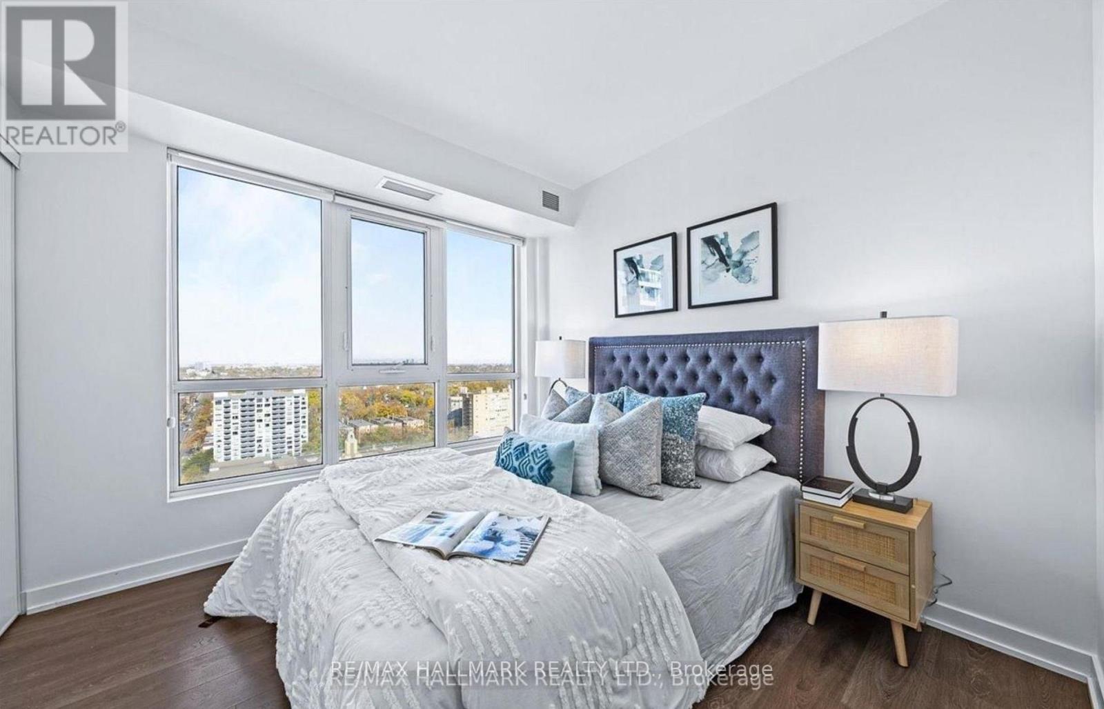 A bedroom with a large bed and a view of the city.