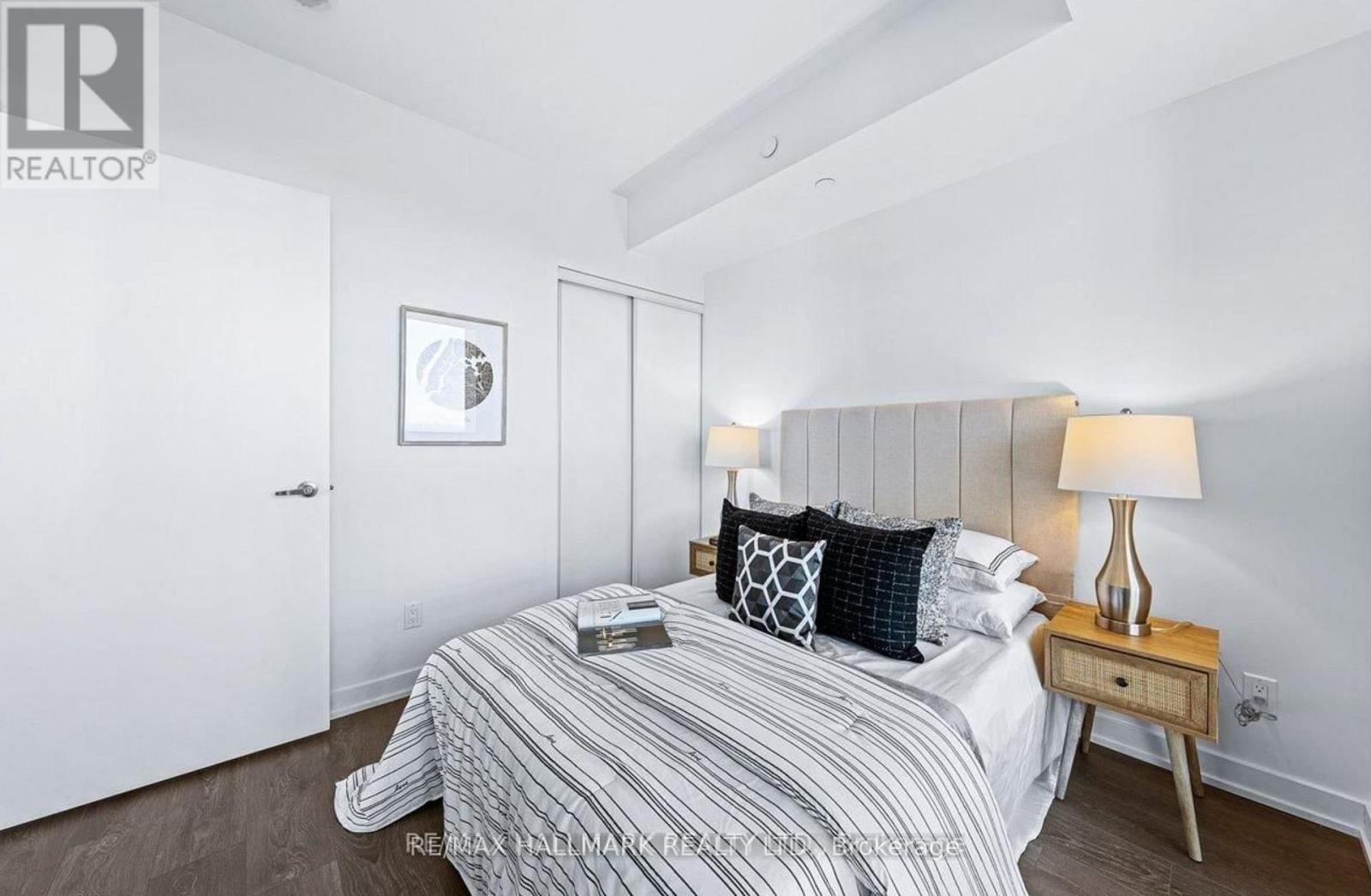 A bedroom with a bed, nightstand, and lamp.