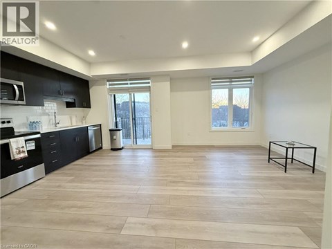 A spacious kitchen with black cabinets and a dining table.