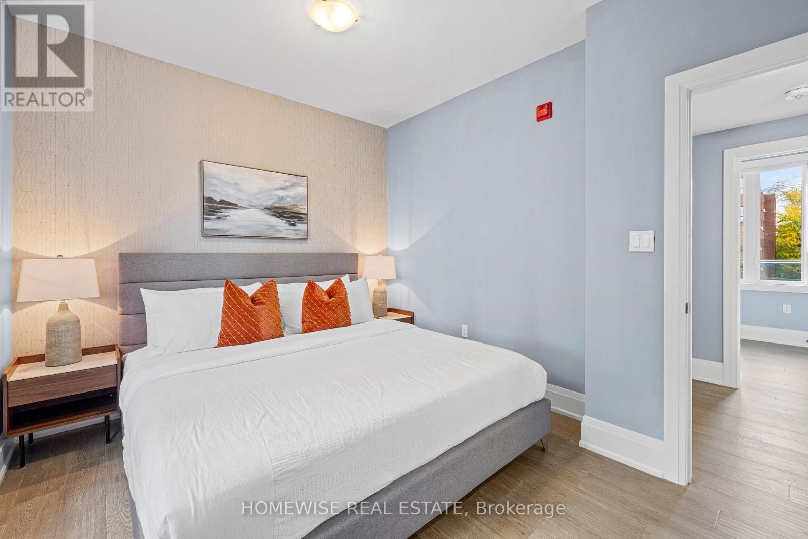A bedroom with a large bed and a painting on the wall.