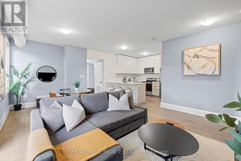 A living room with a grey couch and a round table.