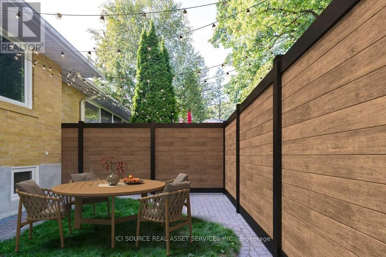 A patio with a table and chairs is surrounded by a wooden fence.