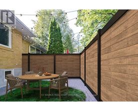 A patio with a table and chairs is surrounded by a wooden fence.