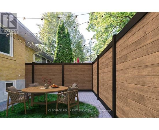 A patio with a table and chairs is surrounded by a wooden fence.