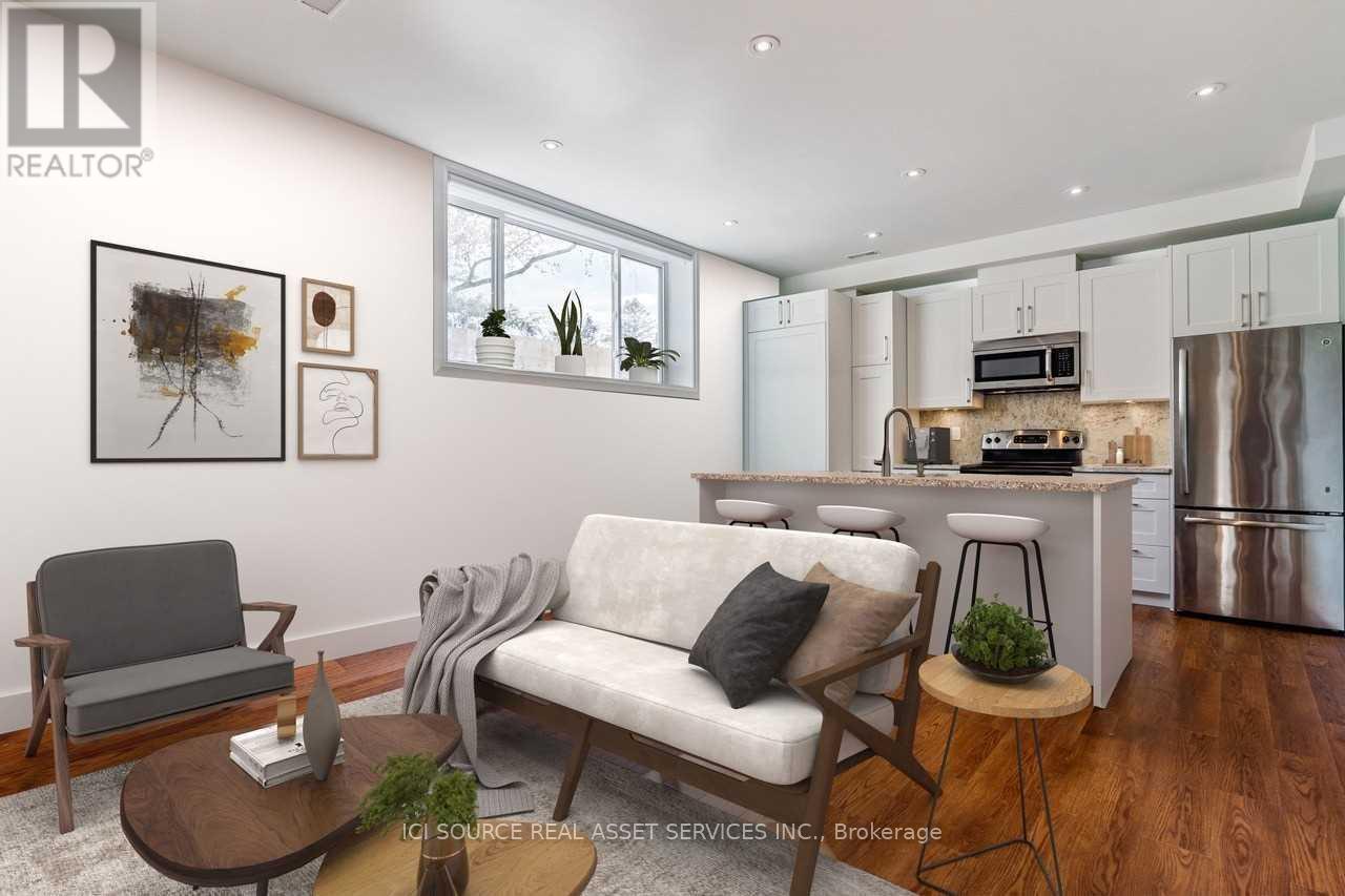 A modern living room with a grey sofa, a wooden coffee table, and a kitchen area in the background.