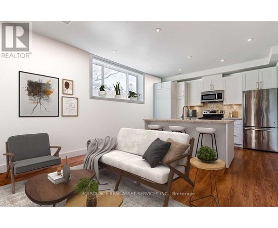 A modern living room with a grey sofa, a wooden coffee table, and a kitchen area in the background.