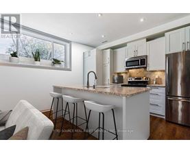 A modern kitchen with a granite countertop and stainless steel appliances.