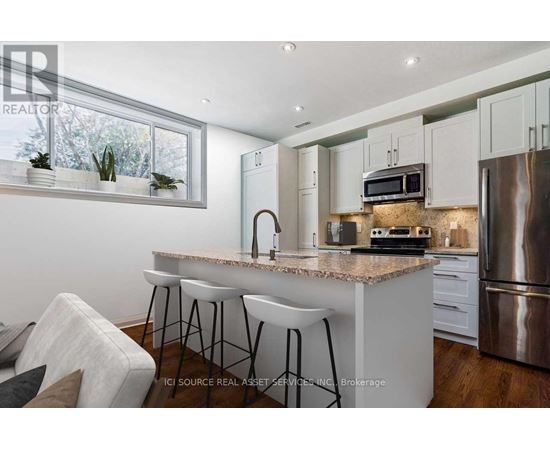 A modern kitchen with a granite countertop and stainless steel appliances.