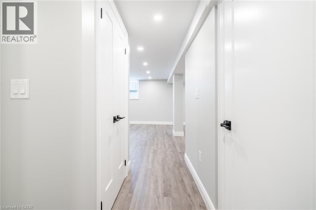 A long hallway with white walls and wood flooring.