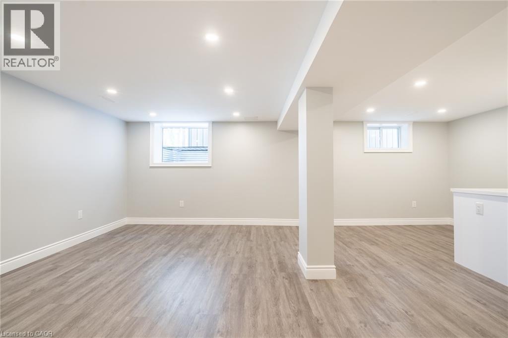 A spacious room with light wood flooring and white walls.