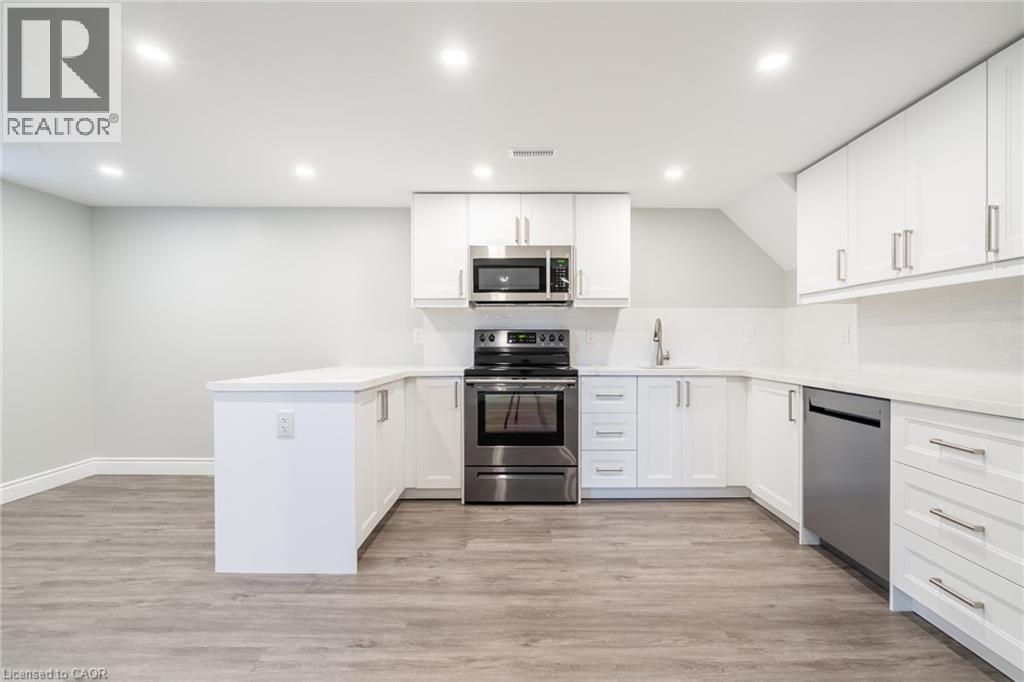 A modern kitchen with white cabinets and stainless steel appliances.