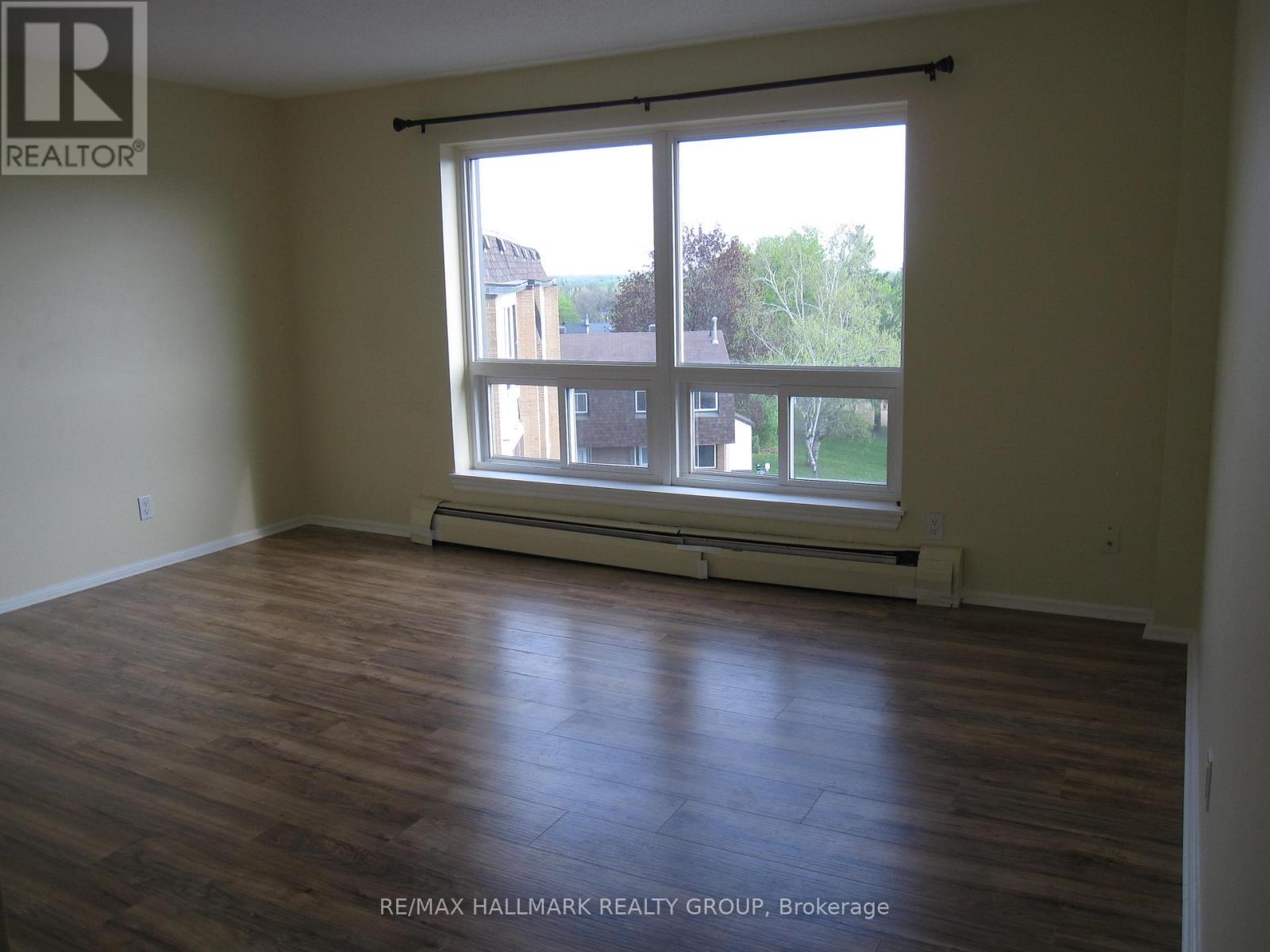 A room with a large window and wooden flooring.