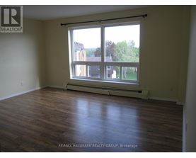A room with a large window and wooden flooring.