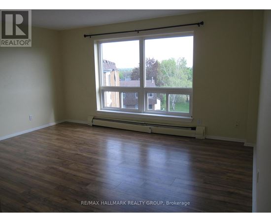 A room with a large window and wooden flooring.