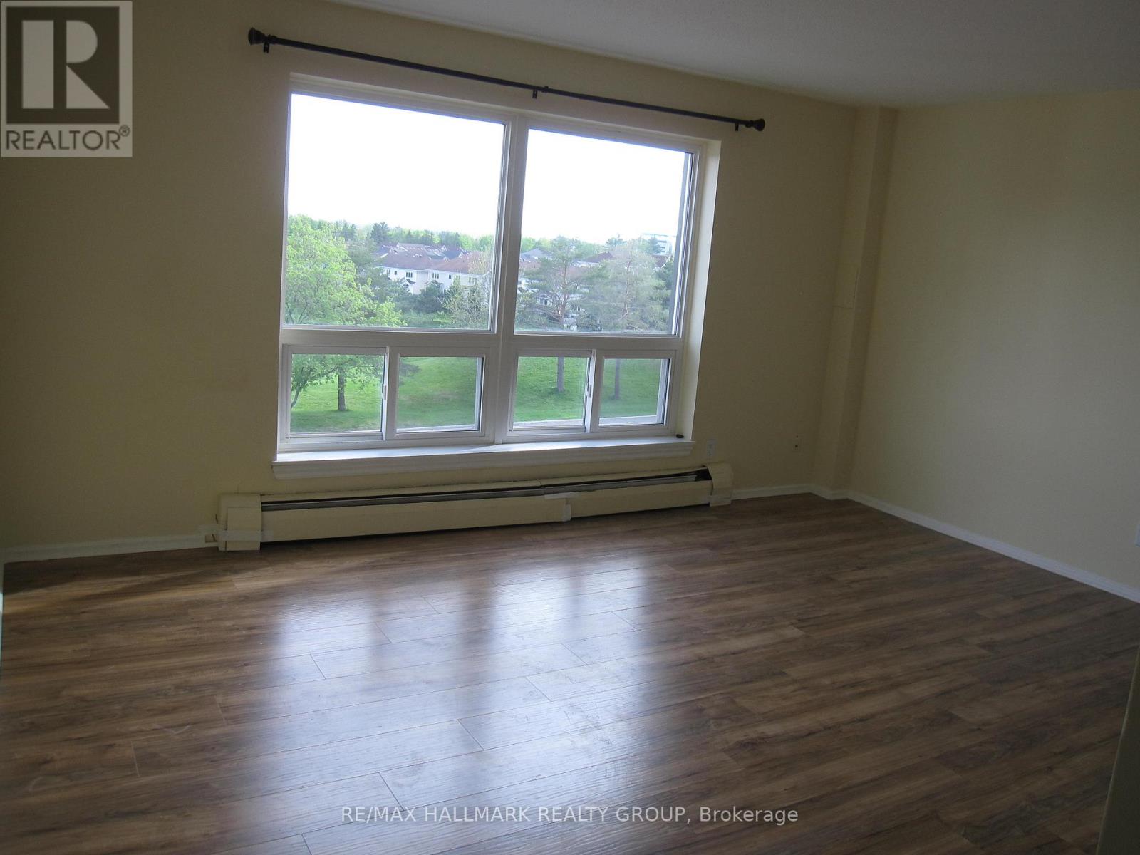 A room with a large window and wooden flooring.
