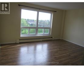 A room with a large window and wooden flooring.