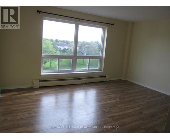 A room with a large window and wooden flooring.