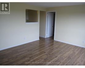 A room with wooden flooring and a door on the right side.