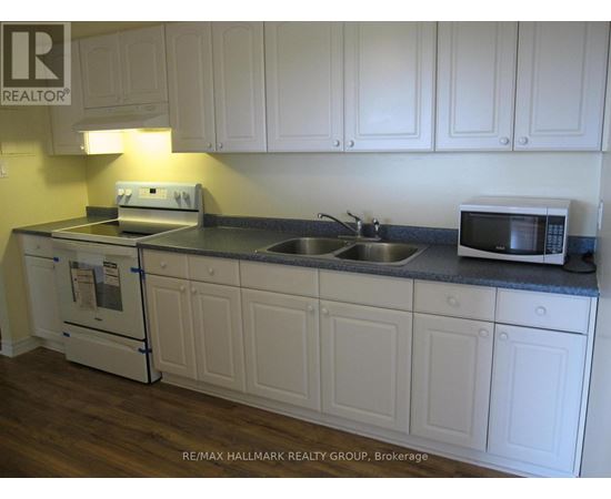 A kitchen with white cabinets and a black countertop.