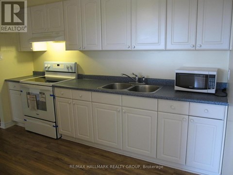 A kitchen with white cabinets and a black countertop.