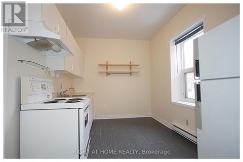 A small kitchen with a white stove top oven and a white refrigerator.
