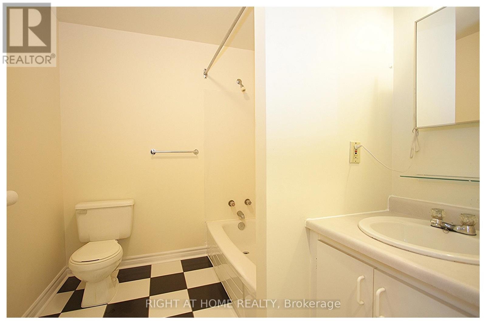 A bathroom with a toilet, tub, and sink.
