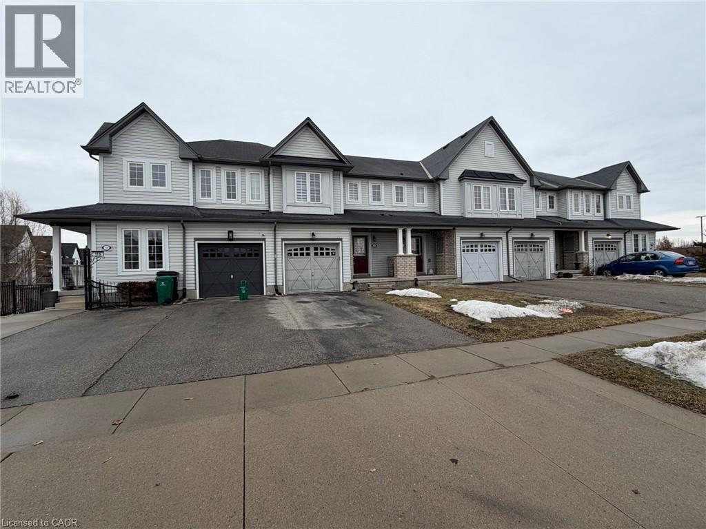 A large, two-story house with a garage and a driveway in front.