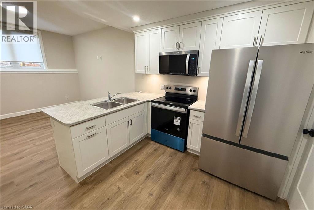 A kitchen with a stove, refrigerator, and cabinets.