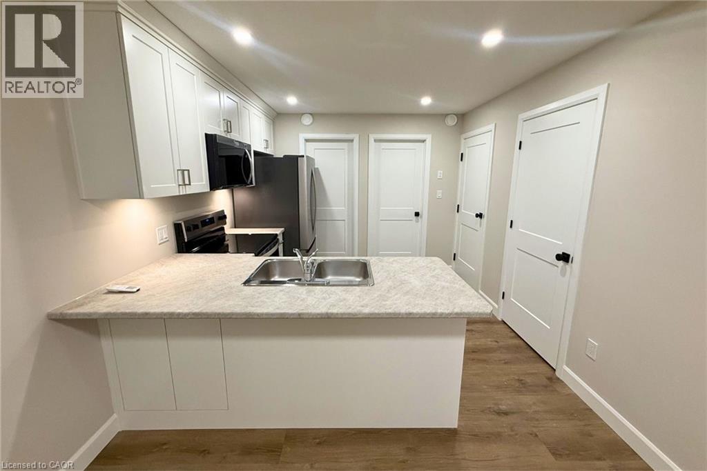 A kitchen with a sink, microwave, and oven.