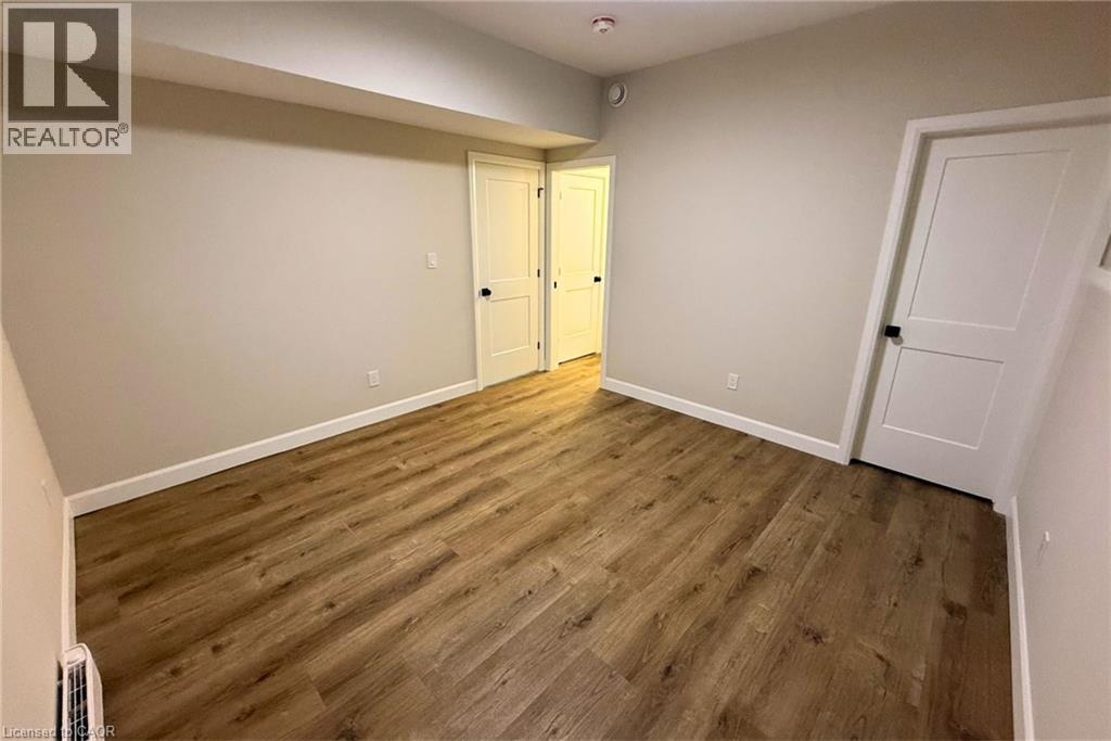 A room with wooden flooring and two doors.