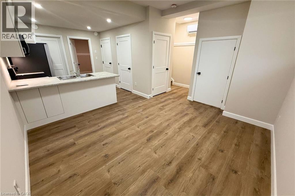 A spacious room with wooden flooring and white walls.