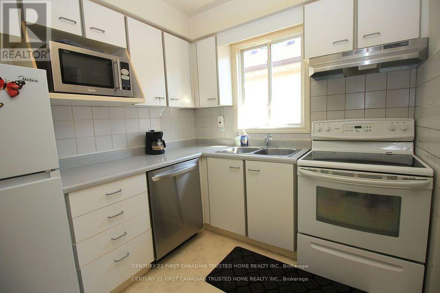 A kitchen with white cabinets and appliances.