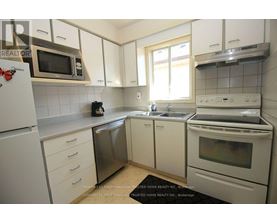 A kitchen with white cabinets and appliances.