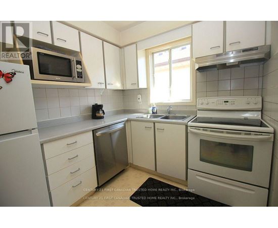 A kitchen with white cabinets and appliances.
