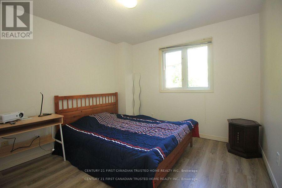 A bedroom with a bed, nightstand, and window.