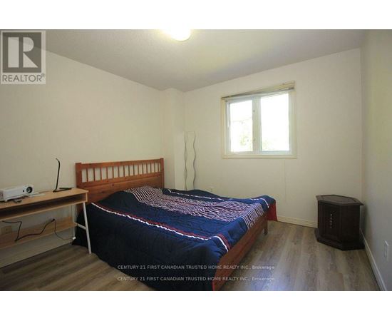 A bedroom with a bed, nightstand, and window.