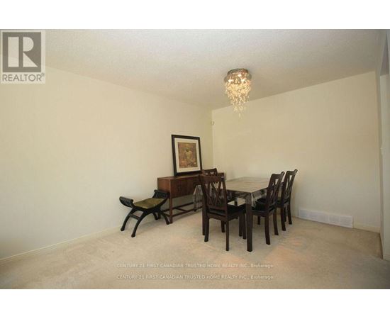 A dining room with a wooden table and chairs.