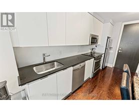 A modern kitchen with white cabinets and stainless steel appliances.