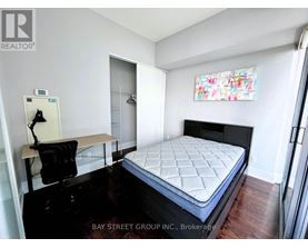 A bedroom with a bed, desk, and chair.